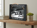 A rectangular black decorative sign with a rustic twine handle and corner ties, displayed on a wooden shelf. The sign features a black-and-white photo of a hockey and reads 'WHATEVER MAKES YOU HAPPY' at the top and 'DO MORE OF IT' at the bottom.