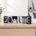 A sign spelling out "GOALIE" in hockey goalie photos, sitting on a light wood dresser in a hockey goalie bedroom setting.
