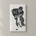 A white single-toggle light switch plate decal featuring a black hockey player silhouette filled with hockey-related words and phrases, shown on a light beige wall.