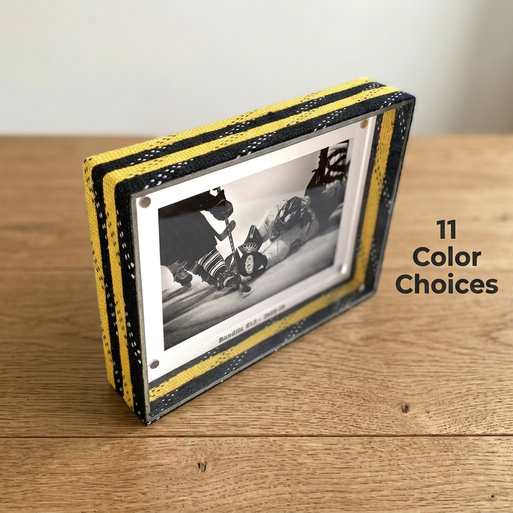 A rectangular photo frame with a black and yellow hockey laces border, holding a black-and-white hockey photograph, displayed on a wooden tabletop. Text on the right reads '11 Color Choices'.