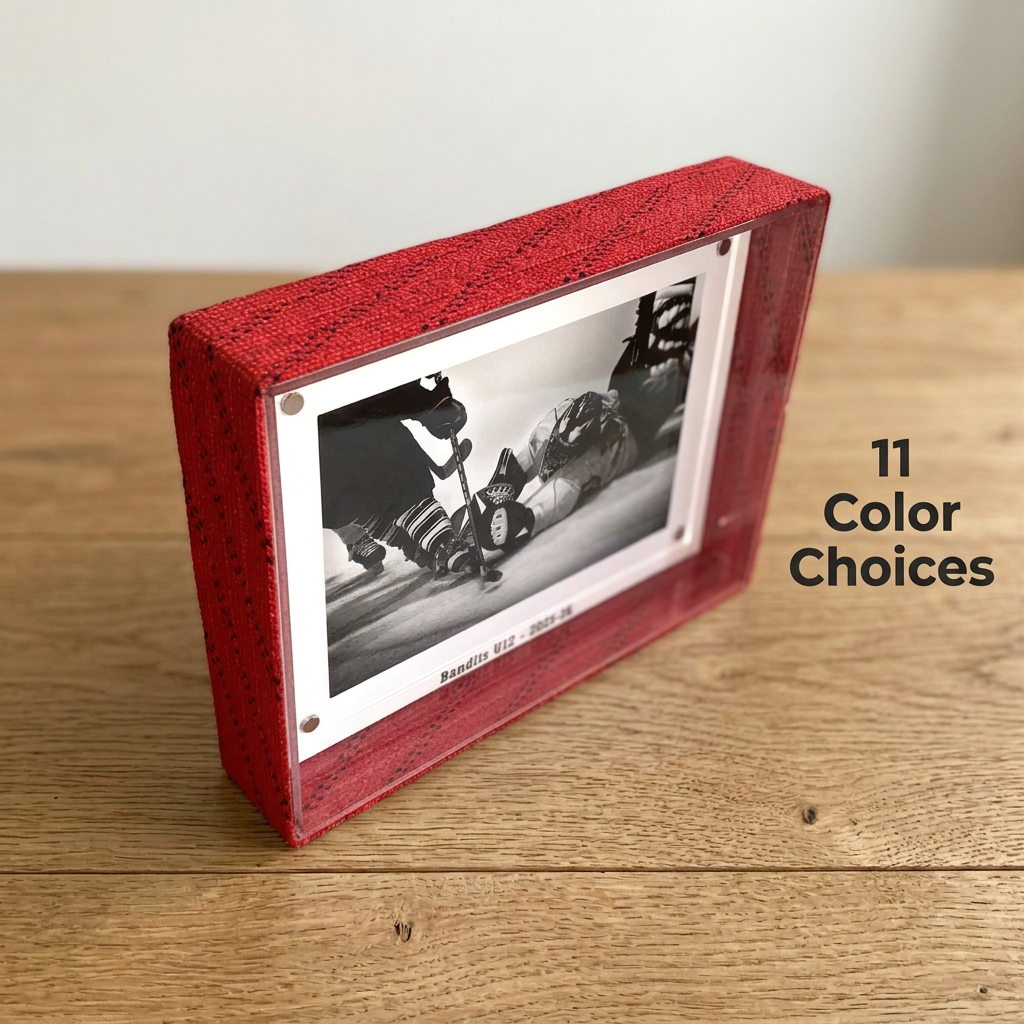 A red hockey laces picture frame with a black-and-white hockey photo insert, shown on a wooden tabletop against a light wall. Text on the right reads '11 Color Choices'.