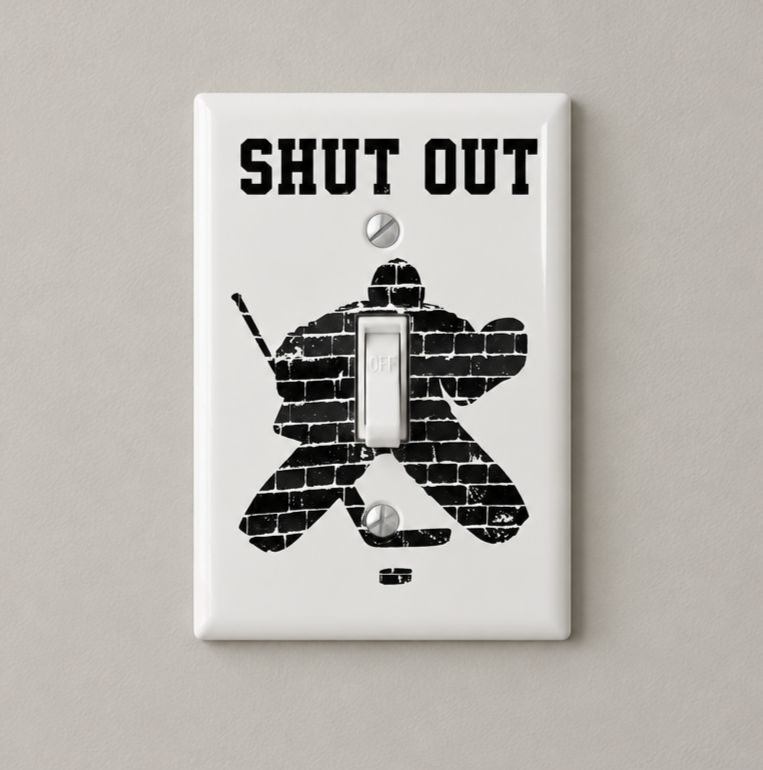 A white single light switch plate cover featuring a black hockey goalie graphic made of brick textures and the distressed text 'SHUT OUT' above it, shown on a white background.