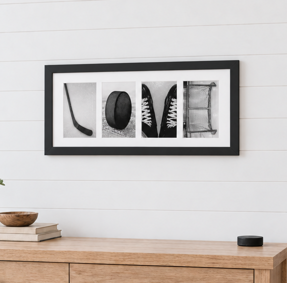 A framed horizontal black and white collage print featuring hockey-themed photos of the letters, spelling out the word "LOVE" mounted on a white shiplap wall above a light wood console table with hockey props.
