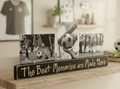 A wooden photo display sign with the phrase 'The Best Memories are Made Here' in lasered lettering, holding three black-and-white soccer-themed photographs, displayed on a wooden shelf in a softly blurred indoor setting.